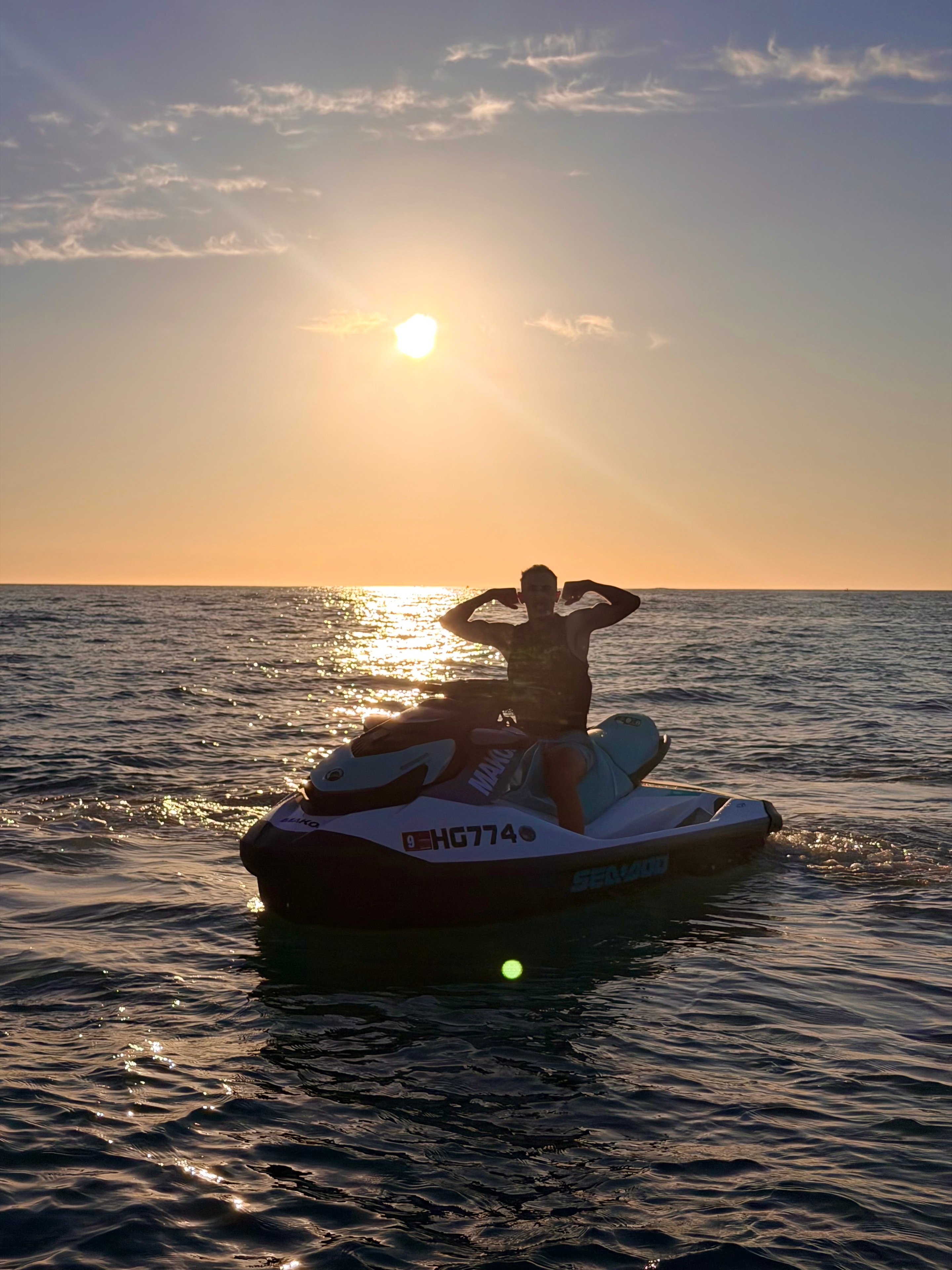 Jet ski rider cruising along the coast at sunset